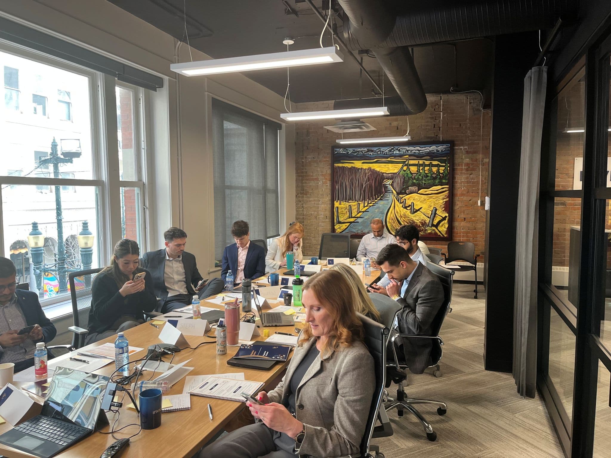 Professionals working around a table in a bright executive workshop room