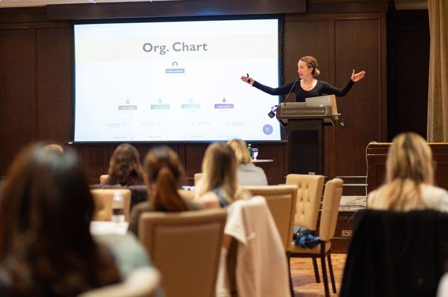 Speaker presenting an organization chart to a seated audience