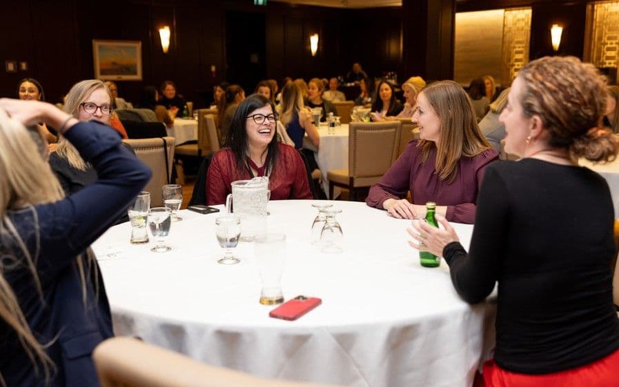 Participants laughing during a round-table learning conversation
