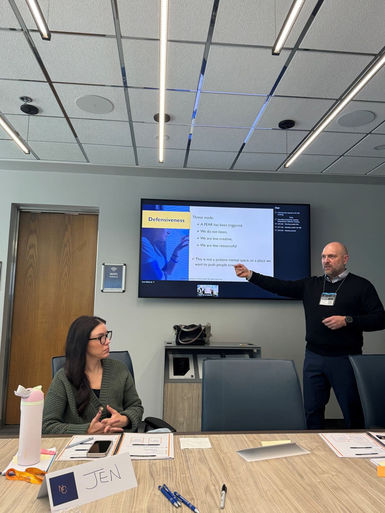 Instructor presenting a defensiveness concept during conflict resolution training