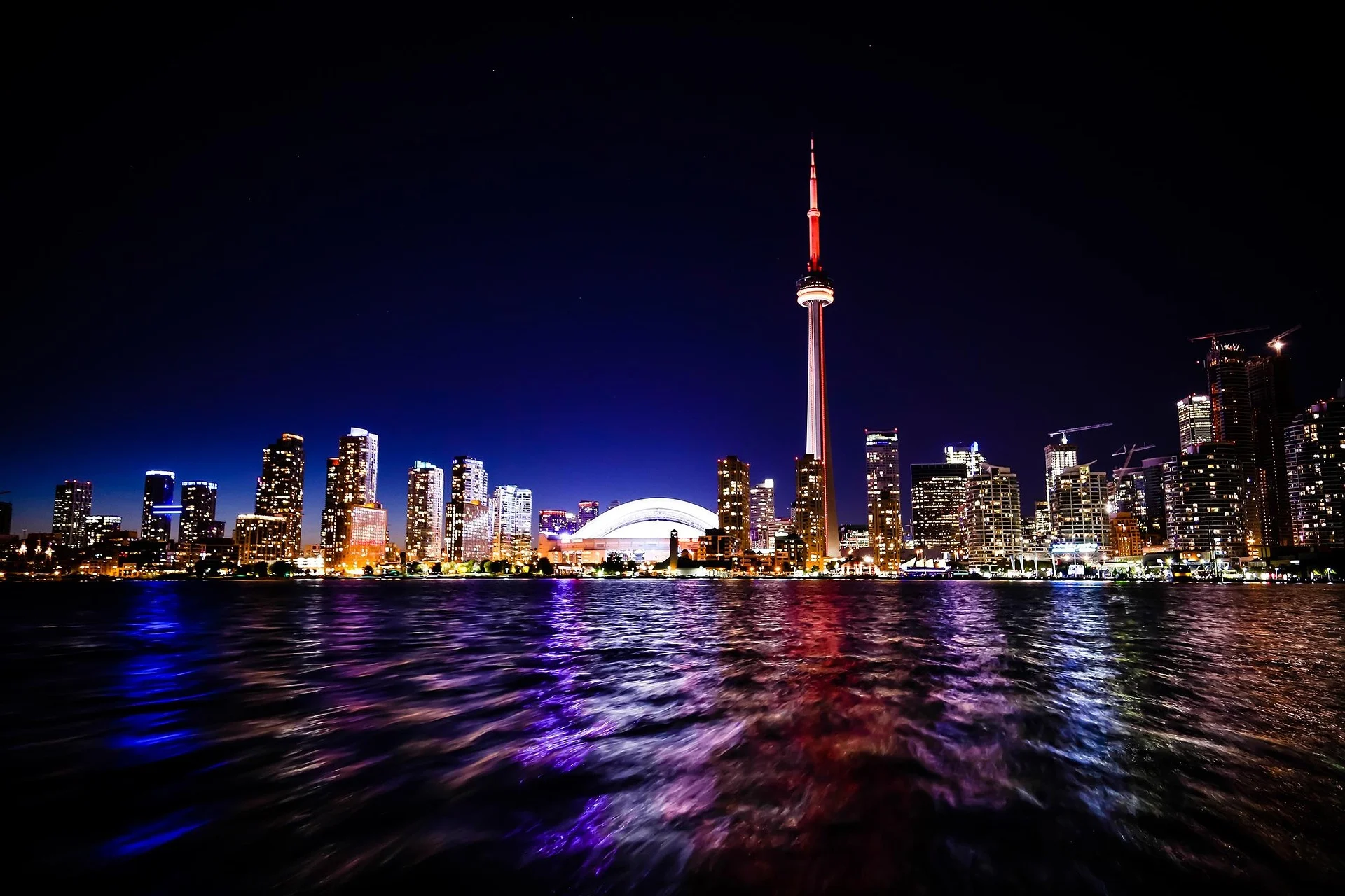 Toronto skyline and the CN Tower illuminated above Lake Ontario