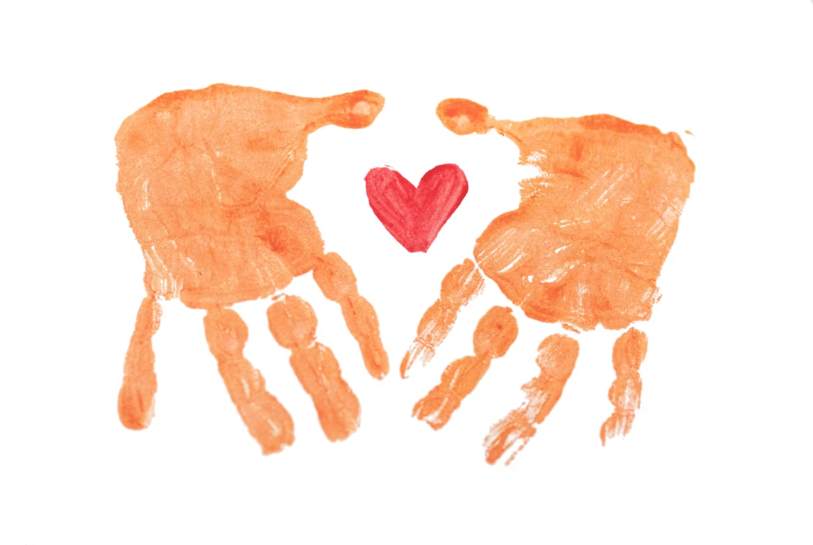 Orange painted handprints surrounding a red heart
